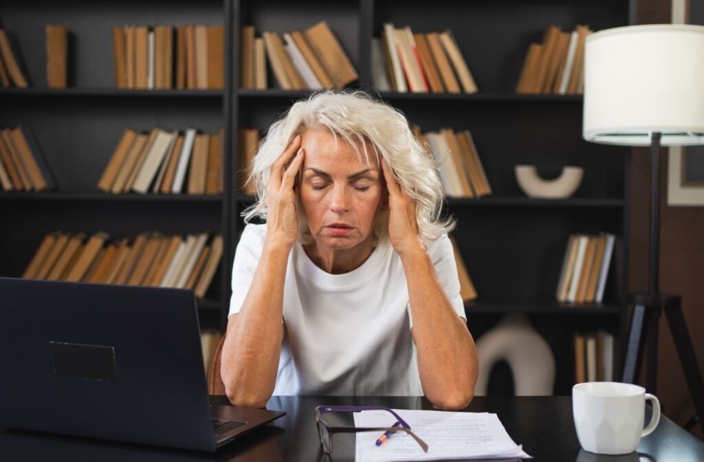 A person rubbing their temples with their fingers for headache relief.