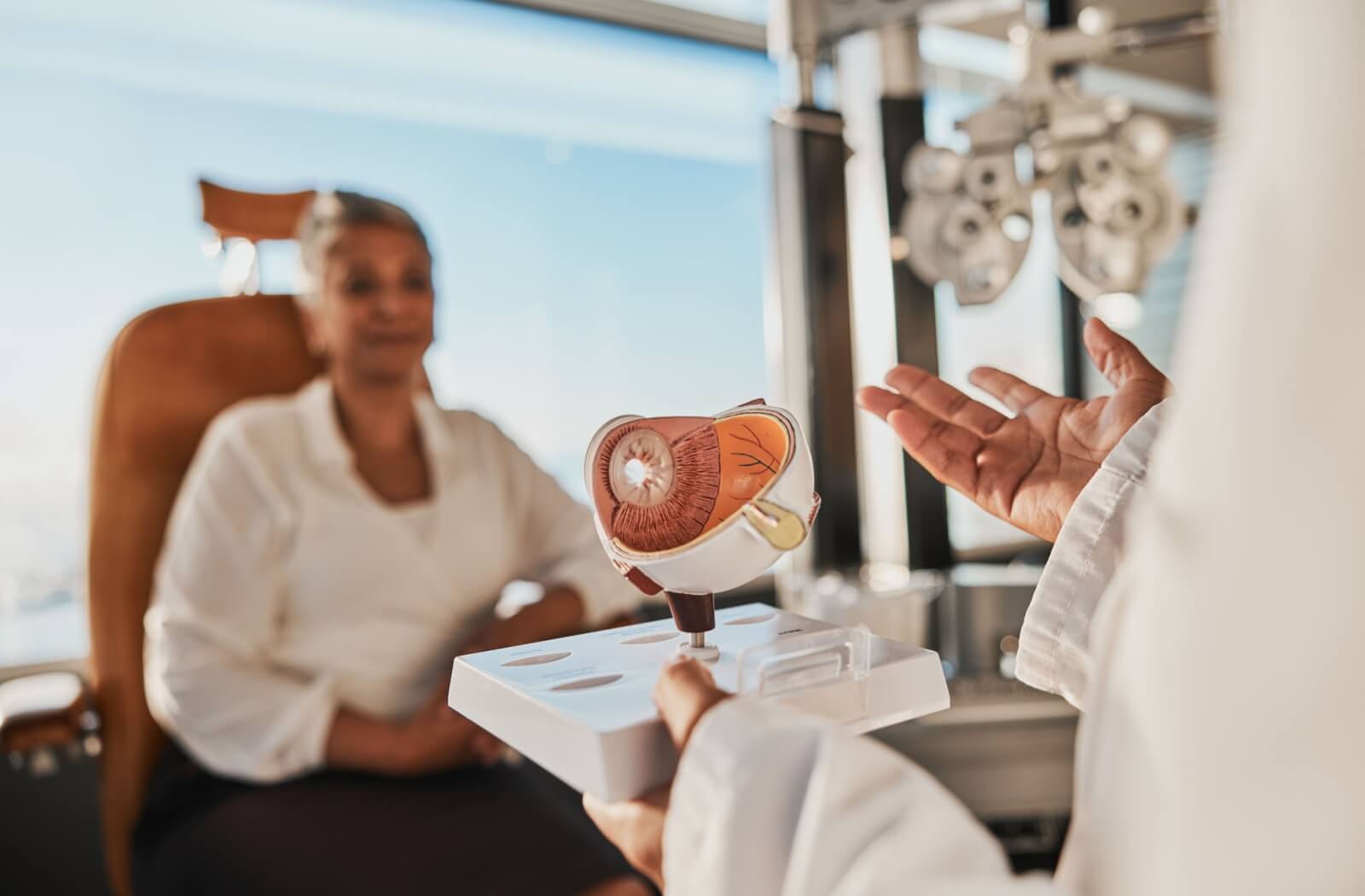 An eye doctor uses an anatomical model of the human eye to explain the possible link between dry eyes and headaches.